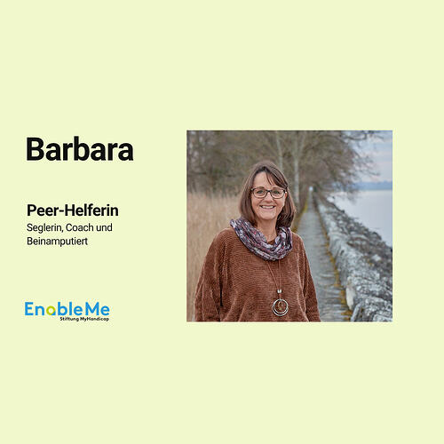 Barbara, Peer-Helferin, Seglerin, Coach und Beinamputierte, lächelt in die Kamera. Sie steht draußen auf einem Weg am Wasser. Logo von EnableMe unten links.