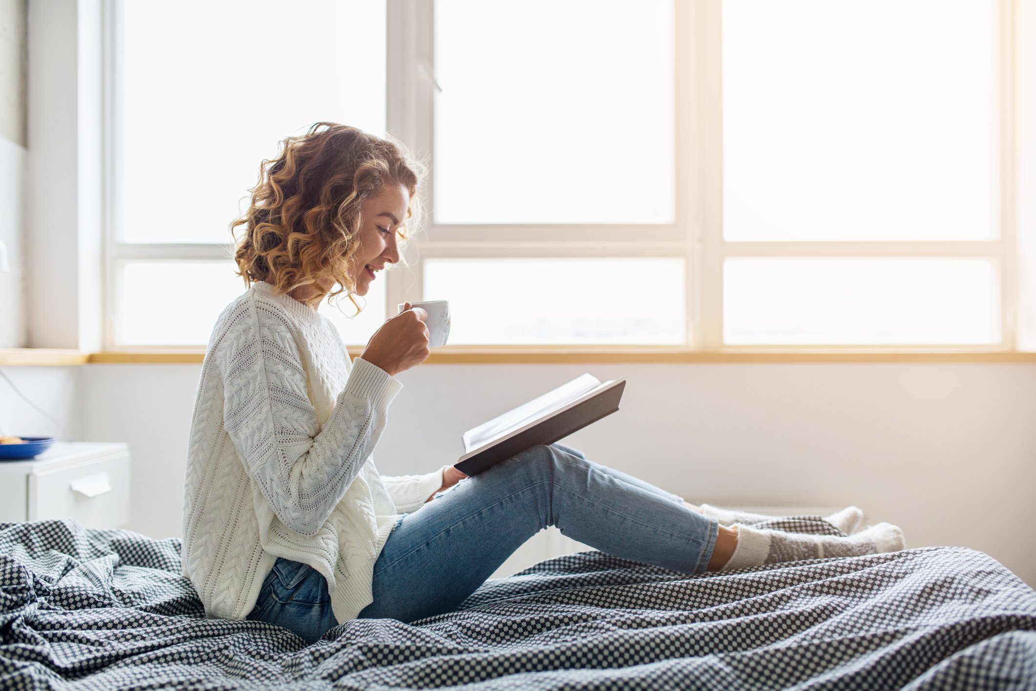 beautiful-young-woman-sitting-bed-morning-reading-book-wearing-white-knitted-sweater-drinking-coffee.jpg