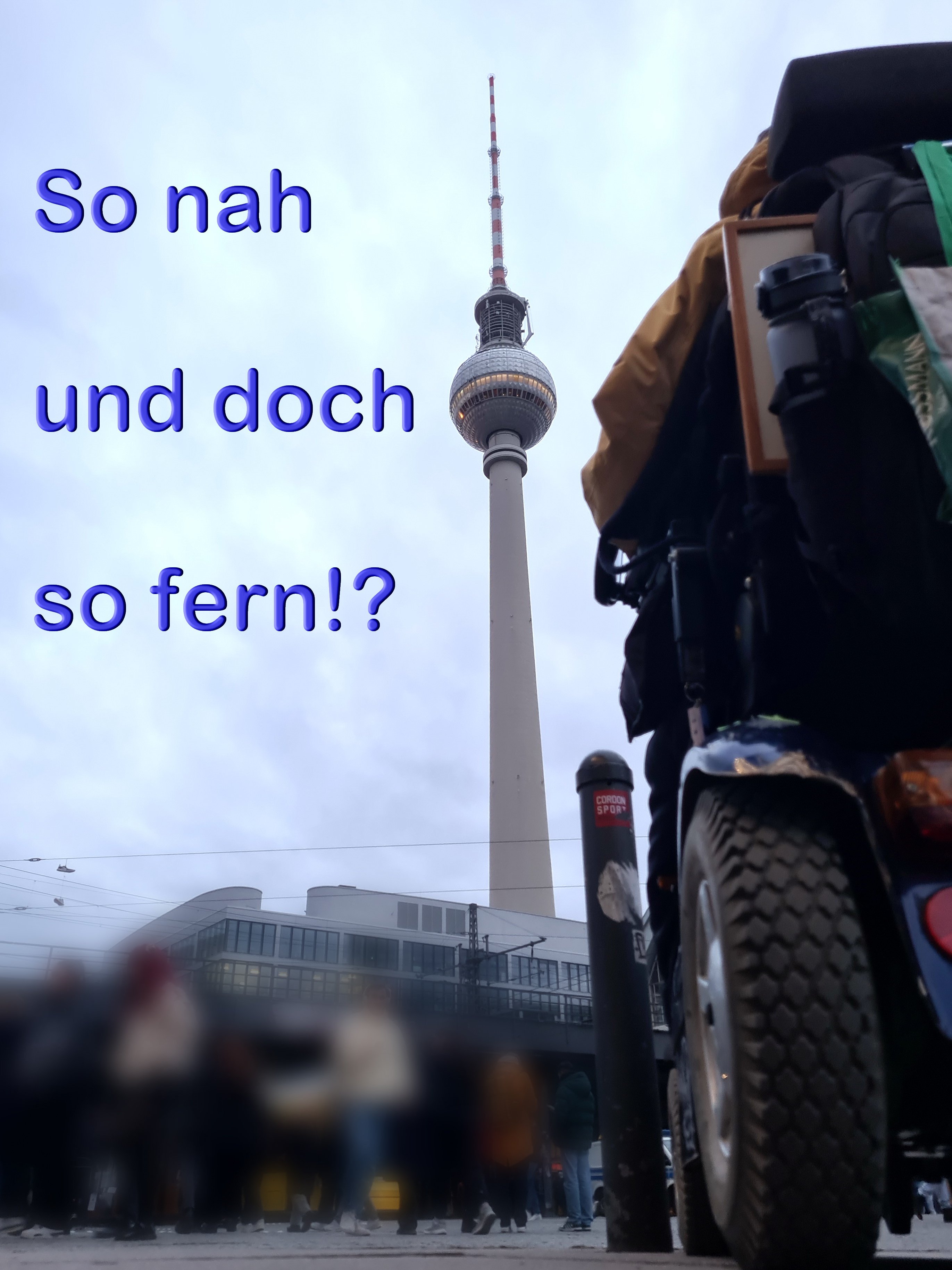 Ein Foto vom Berliner Fernsehturm. Der Protagonist des Posts ist von hinten in seinem Rollstuhl vor der Aussicht zu sehen. Über dem Himmel ist der Schriftzug