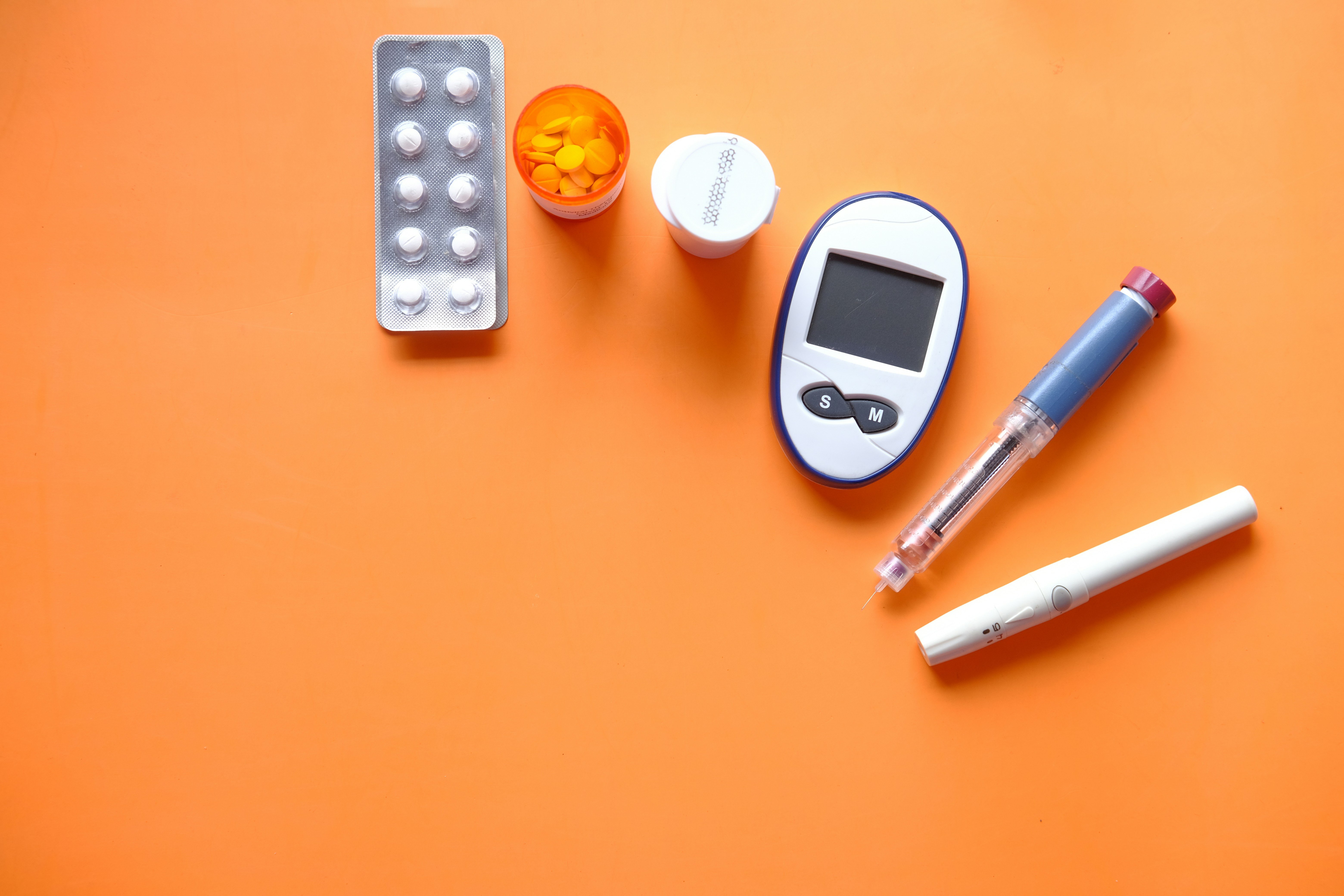 Diabetes Hilfsmittel auf einem orangen Hintergrund